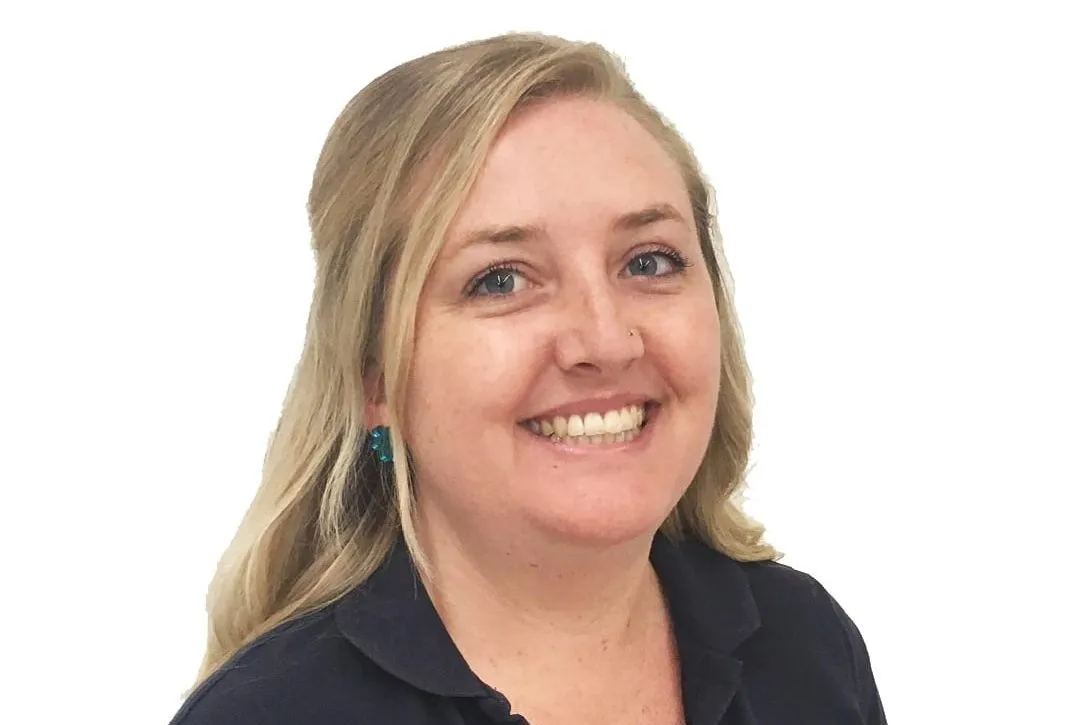 A woman in a navy Myhorizon polo shirt smiling at the camera, photographed against a plain white background.