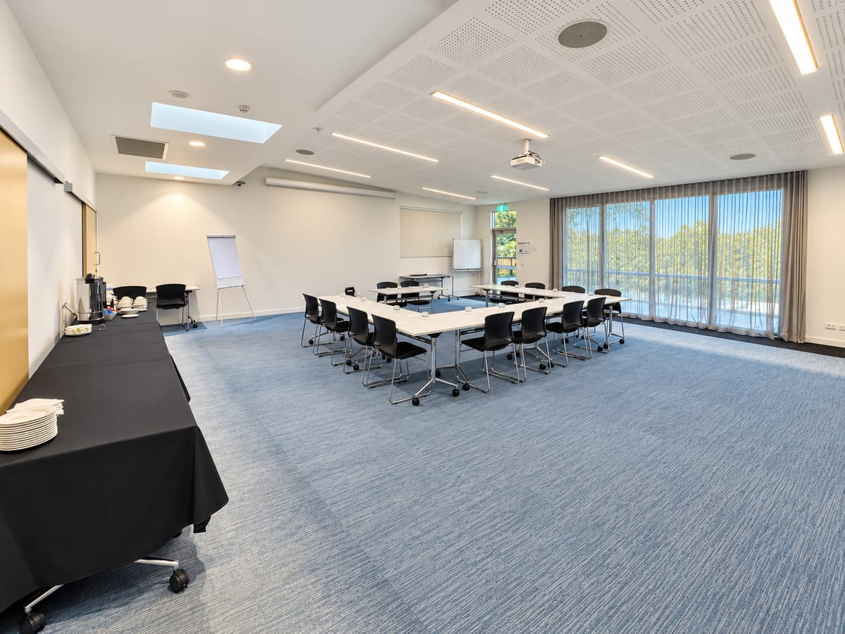 The Banksia Room with tables set in a U-shape, and windows along one wall