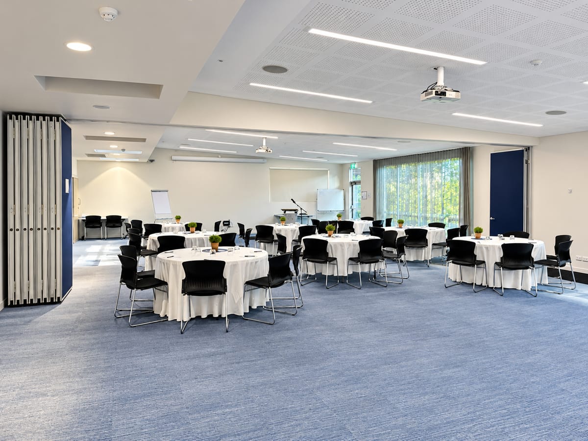 The Forest View Room with round tables set in white linen, and a folding wall on the left