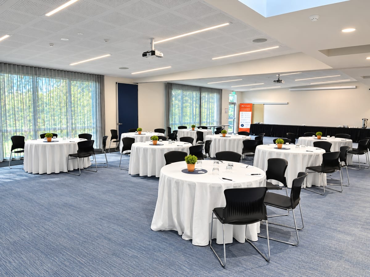 The Forest View Room set with banquet rounds, white linen and a data projector
